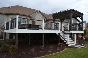 A beautifully elevated deck with a pergola, featuring stylish railings and a spacious staircase, attached to a modern home. The deck provides ample space for outdoor seating and dining, enhancing the home's outdoor living area. This project showcases the expert craftsmanship of C-U Under Construction, your trusted deck contractor in Champaign, IL.