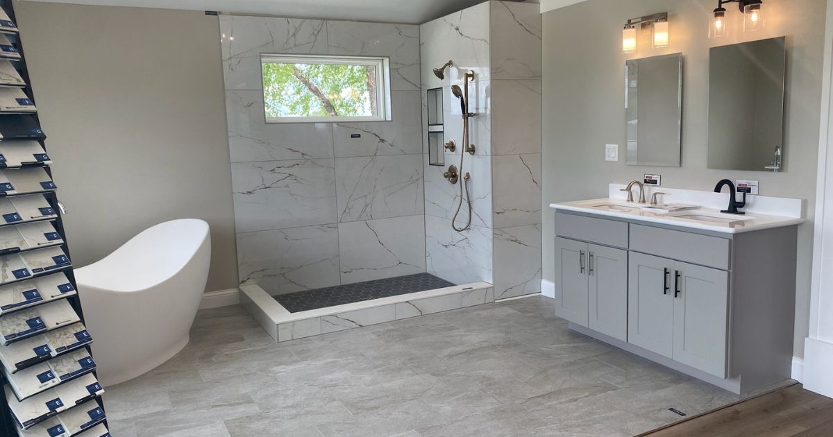 Bathroom showroom display featuring a walk-in shower, freestanding tub, and double-sink vanity.