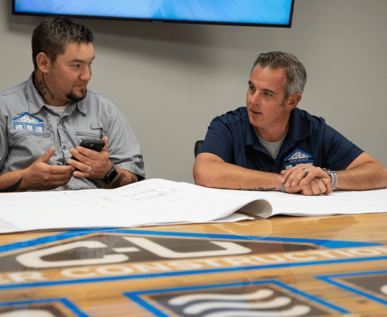 Team members at C-U Under Construction collaborating on project plans in the conference room.