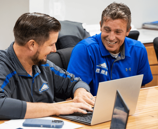 C-U Under Construction team members working together on project planning at a laptop.