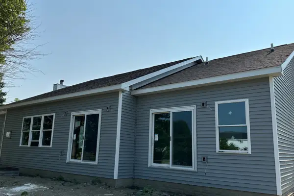 Home exterior with new gray vinyl siding and replacement windows