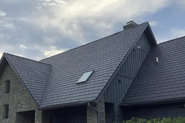 Residential roof replacement with dark architectural shingles and standing seam metal accents by C-U Under Construction in Champaign, IL