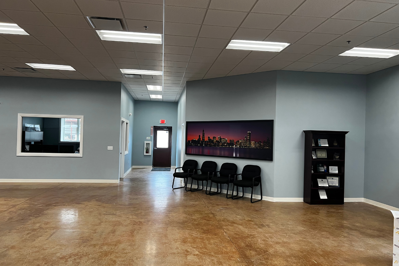 Commercial waiting room with polished concrete floors, drop ceiling, and seating area