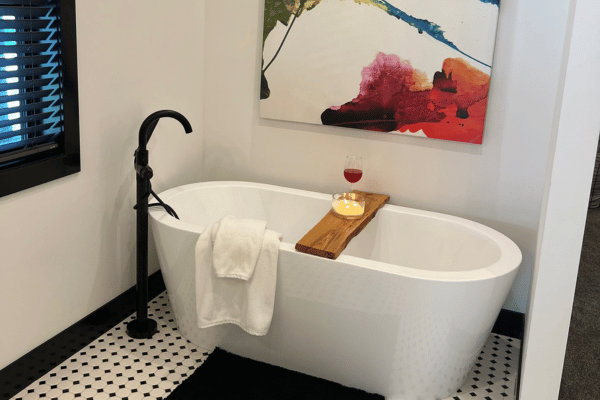 Bathroom remodel with freestanding soaker tub, matte black floor faucet, and black and white tile by C-U Under Construction in Central Illinois