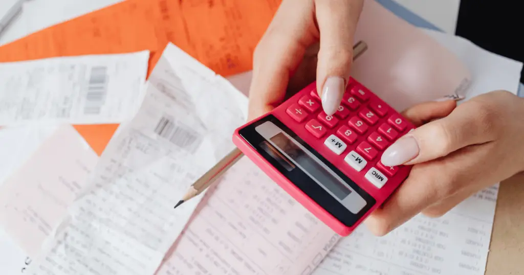 Person reviewing contractor estimates and receipts with a calculator