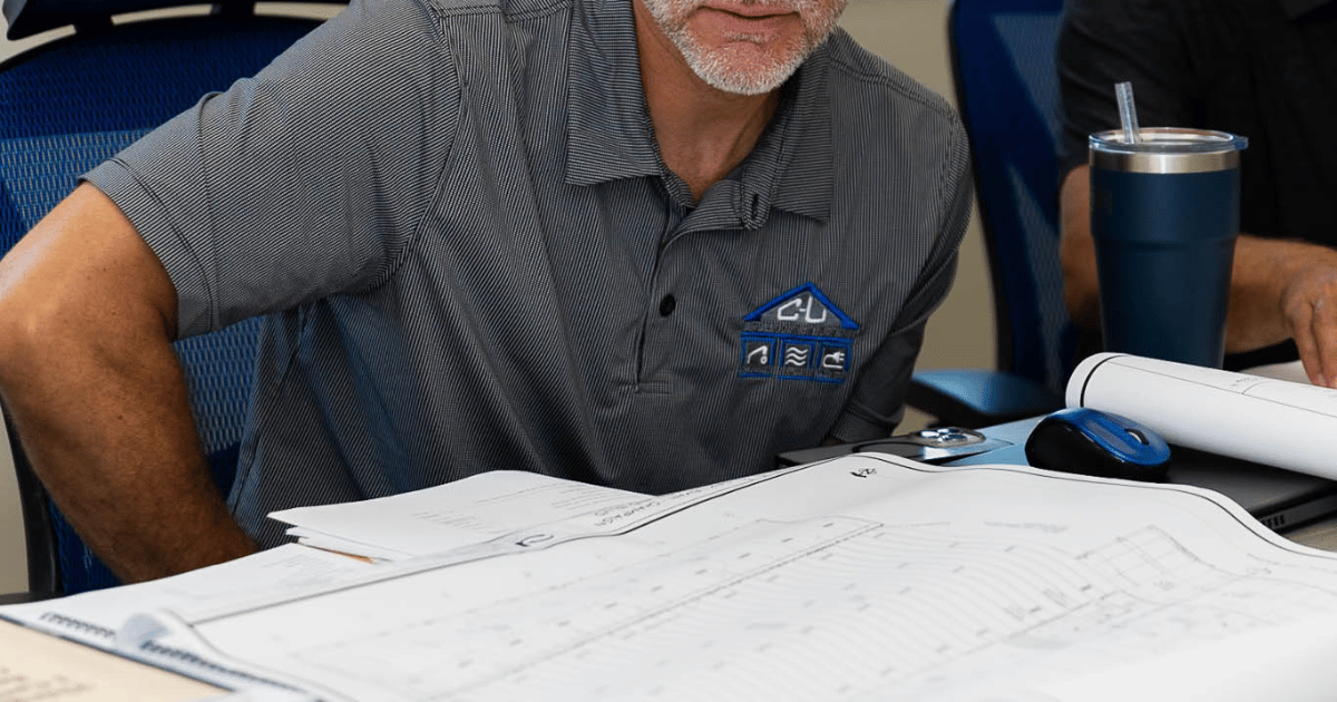 C-U Under Construction team member reviewing project blueprints at a planning meeting in Champaign, IL
