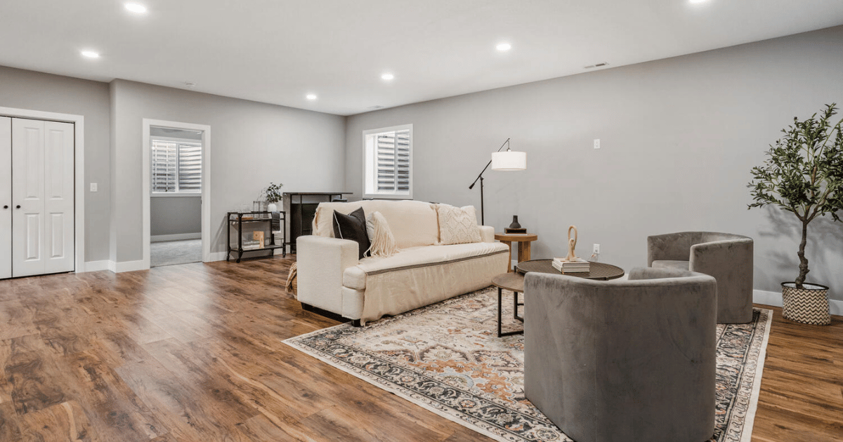 Finished basement living area with hardwood floors, recessed lighting, and open layout
